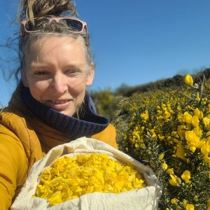 Rachel Lambert stands outdoors with gorse flowers gathered to make sweet treats