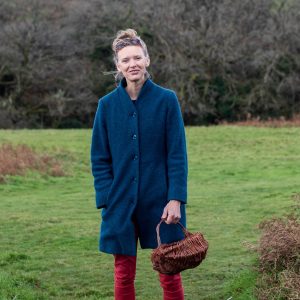 Forager Rachel Lambert standing in a field in autumn with a basket