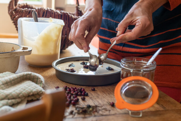 Adding spoons of haw berry jam to the cheesecake topping before baking