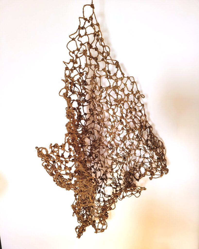 A handmade fishing net from local plants in Penzance hanging up