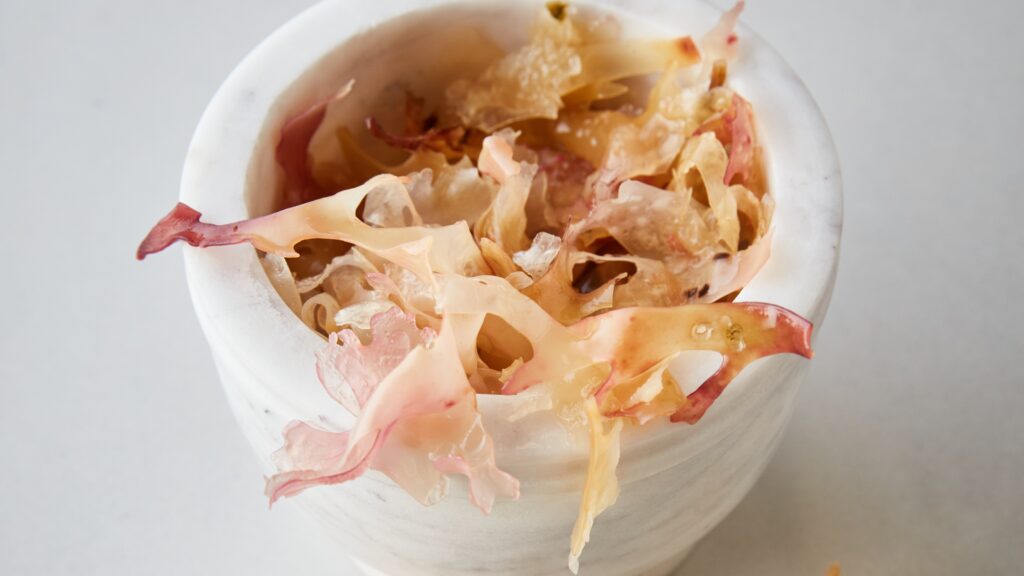 A white ceramic pot with creamy carrageen seaweed spilling out of it