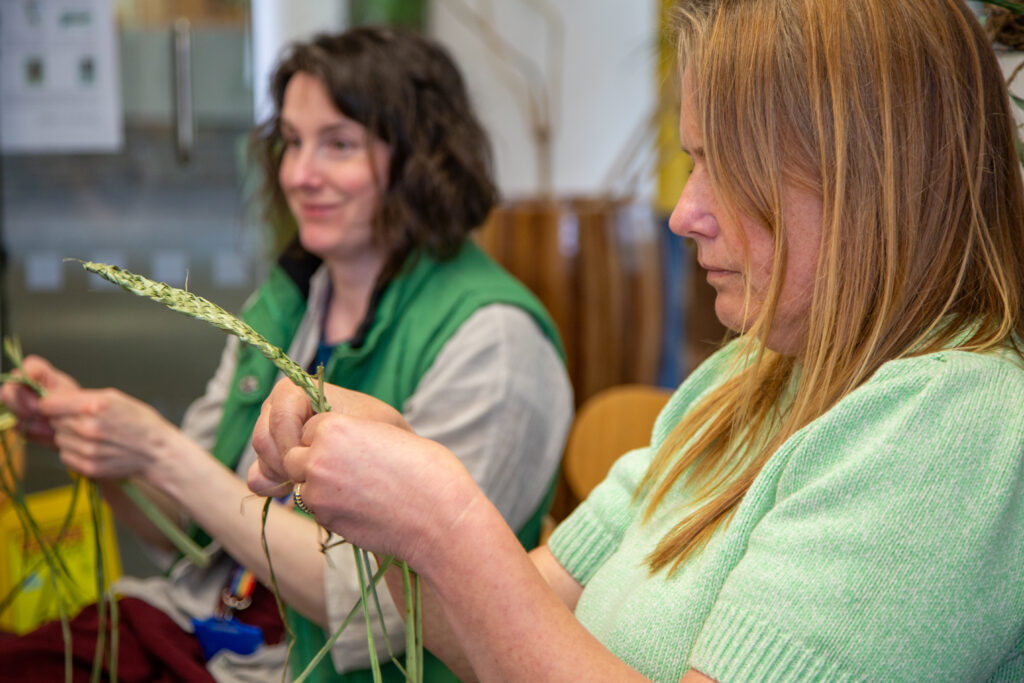 Two women making from plants with a 9-ply plait technique